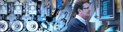 Engineer with machinery in automotive parts factory